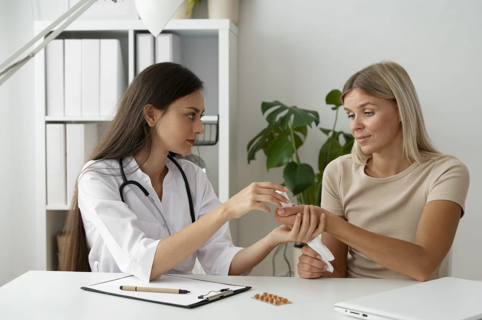 Healthcare provider discussing medication with patient at consultation desk with pills visible